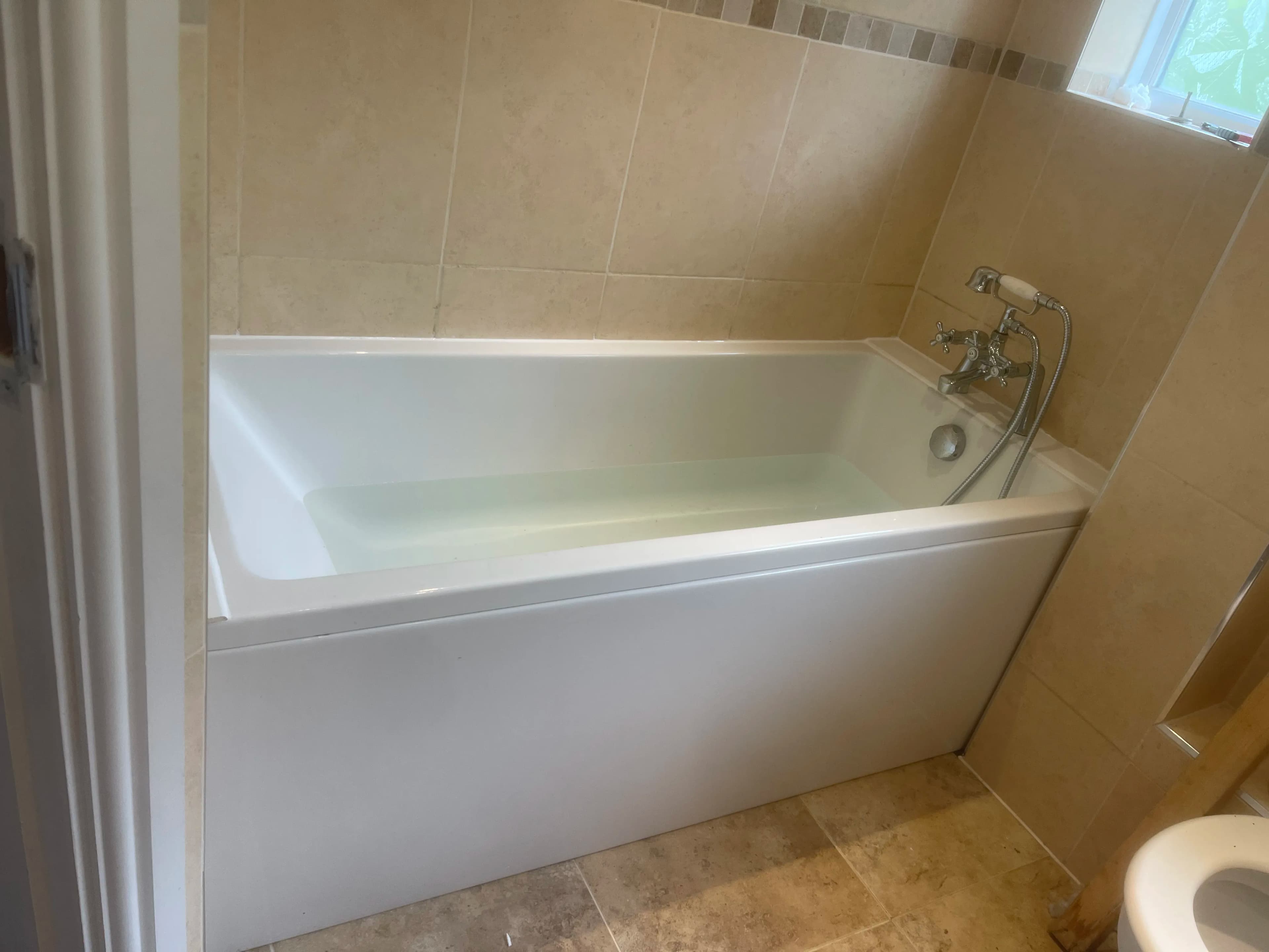 Bath installation with warm natural stone tiles