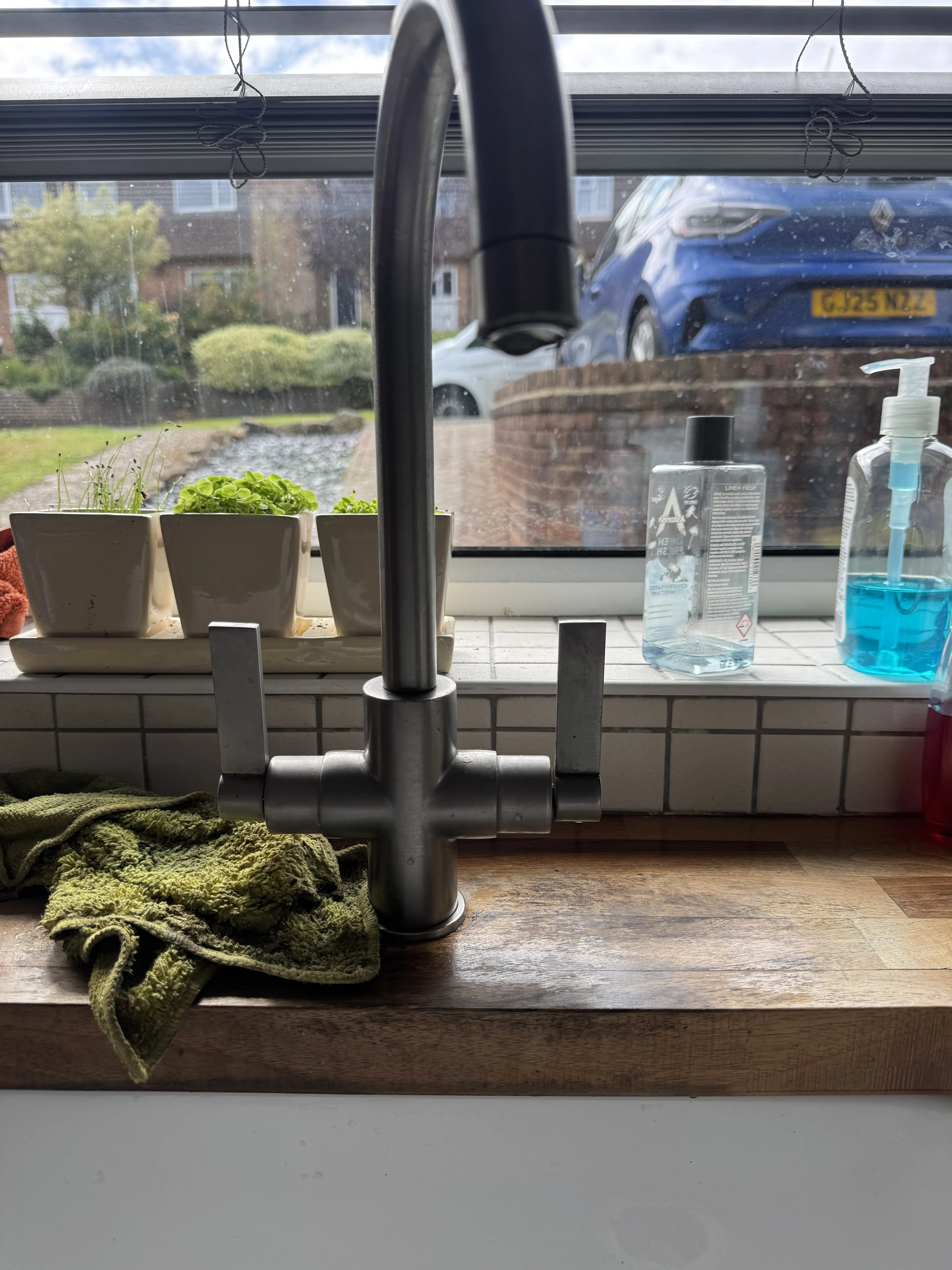 Modern kitchen tap installation on wooden worktop